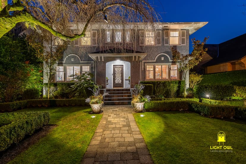 Elegant home exterior at night with landscaped garden and inviting entrance.